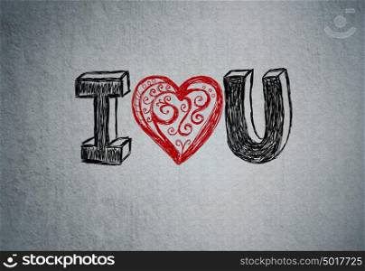 I Love You. Handwritten message on a concrete wall with an illustrated heart used as a symbol of love in this Valentines message.