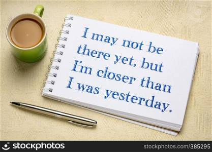 I may not be there yet, but I am closer than I was yesterday - positive affirmation writing in a spiral art sketchbook with a cup of coffee