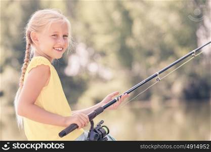 I&rsquo;ll catch big fish!. Portrait of cute girl sitting at bank and fishing