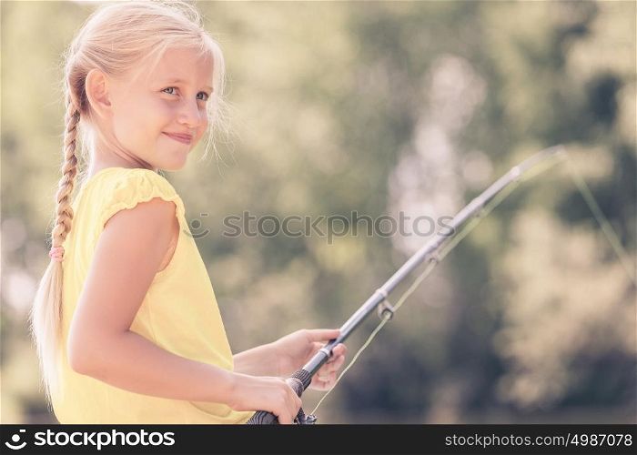 I&rsquo;ll catch big fish!. Portrait of cute girl sitting at bank and fishing