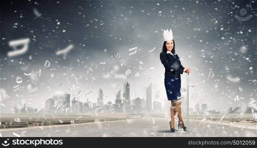 I rule my business!. Young businesswoman in paper crown against city background