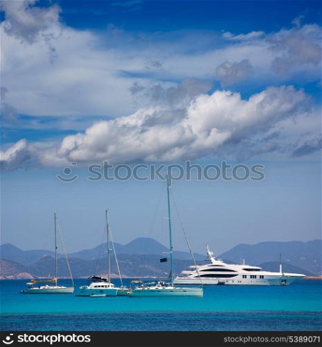 Ibiza coast view from Formentera with anchor boats in blue summer day