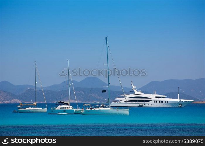 Ibiza coast view from Formentera with anchor boats in blue summer day