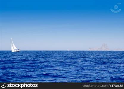 Ibiza Es Vedra and sailboat in blue mediterranean sea
