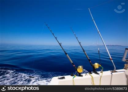 Ibiza fishing boat trolling with rods and reels in blue Mediterranean sea Balearic