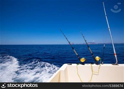 Ibiza fishing boat trolling with rods and reels in blue Mediterranean sea Balearic
