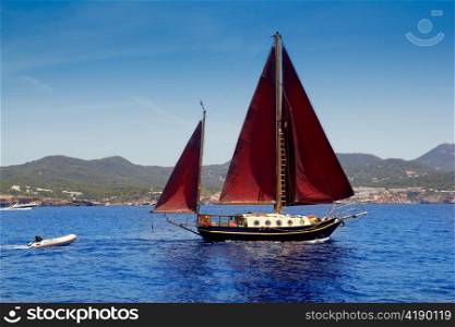 Ibiza Red sails sailboat in Sa Talaia coast of Balearic Islands