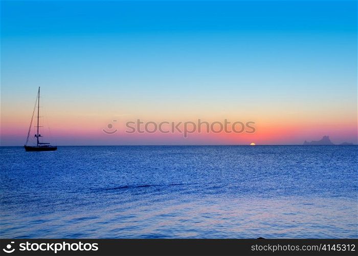 Ibiza sunset from Formentera with Es Vedra and sailboat in Mediterranean