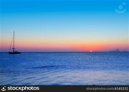 Ibiza sunset from Formentera with Es Vedra and sailboat in Mediterranean