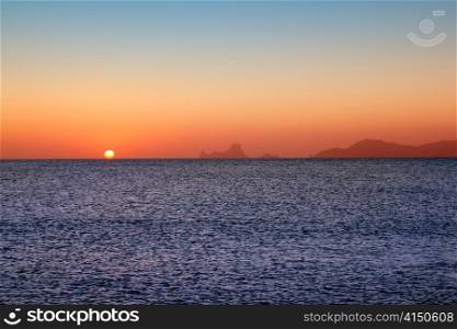 Ibiza sunset from Formentera with Es Vedra mountain in Mediterranean sea
