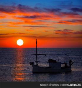 Ibiza sunset view and menorquina fisherboat from Formentera orange sky