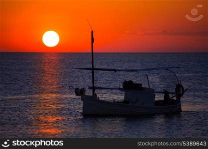 Ibiza sunset view and menorquina fisherboat from Formentera orange sky