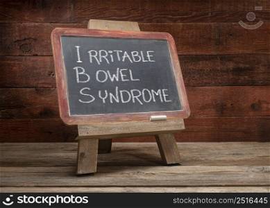 IBS - irritable bowel syndrome, white chalk handwriting on a retro slate blackboard, medical education concept