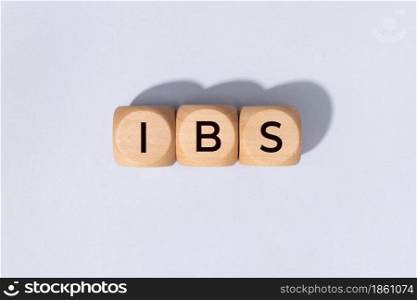 IBS word on woden blocks isolated on gray background. Irritable Bowel Syndrome