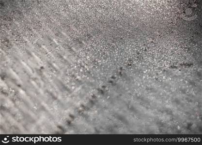 Ice and frost background on frozen glass. Colored in silver or grey tone. Selective focus at center with blur edges of image.. Ice and frost background on frozen glass. Colored in silver or grey tone. Selective focus at center with blur edges of image