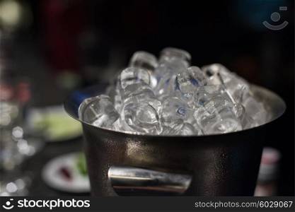 Ice bucket filled with ice cubes closeup. Ice bucket with ice cubes
