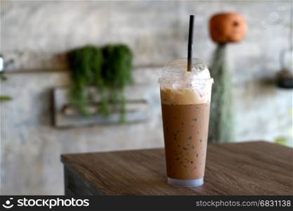 ice coffee in takeaway cup on wooden table