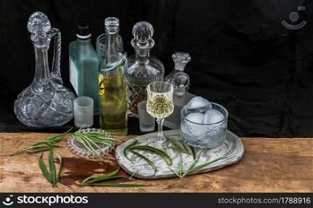 Ice cold Marijuana cannabis CBD infused drink in a crystal clear glass with green marijuana leaf on wooden background. Cannabis cocktail, Medical purposes for sleep and anxiety, Herbal and healthy drinks concept. Selective Focus.