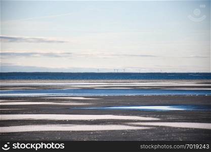Ice covered water pattern with windmills in the horizon by the coast of the Baltic Sea at the swedish island Oland