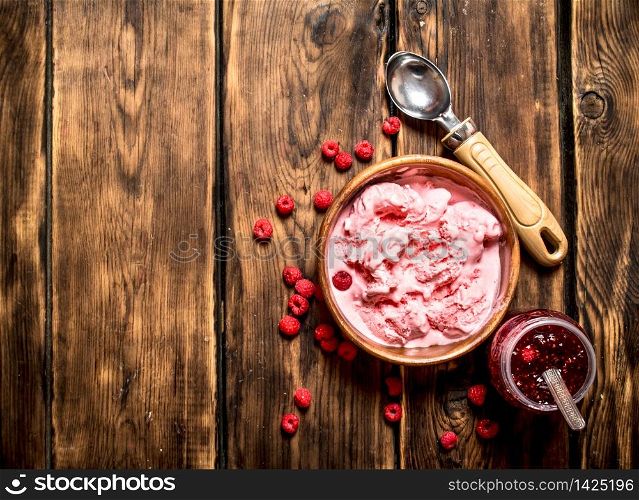 Ice cream and jam made from wild raspberries. On a wooden table.. Ice cream and jam made from wild raspberries.