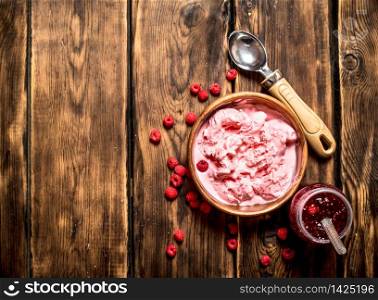 Ice cream and jam made from wild raspberries. On a wooden table.. Ice cream and jam made from wild raspberries.