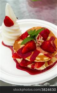Ice cream and strawberry waffle on white plate
