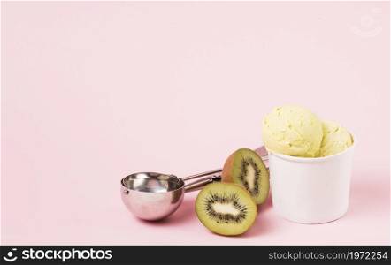 ice cream balls cup near kiwi scoop. High resolution photo. ice cream balls cup near kiwi scoop. High quality photo