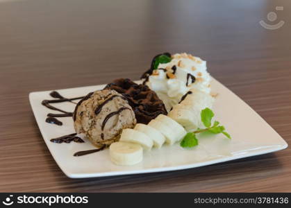 ice cream , banana , chocolate waffles with chocolate sauce and whipping cream