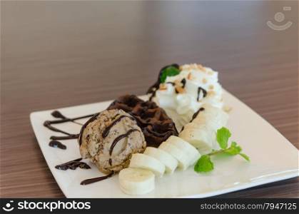 ice cream , banana , chocolate waffles with chocolate sauce and whipping cream