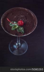 Ice cream chocolate dessert. Ice cream chocolate dessert decorated with cherry on dark brown background