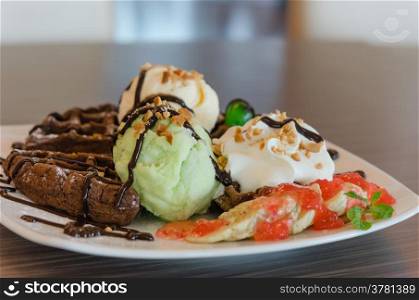 ice cream , chocolate waffles with chocolate sauce and whipping cream