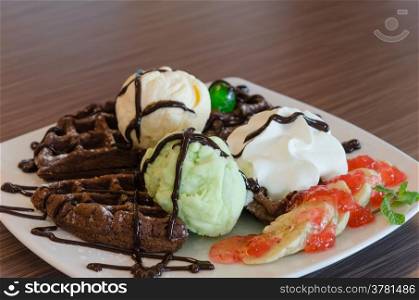 ice cream , chocolate waffles with chocolate sauce and whipping cream
