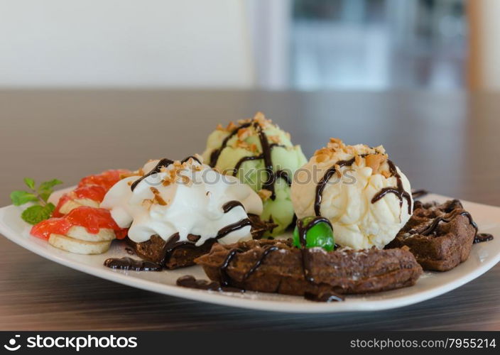 ice cream , chocolate waffles with chocolate sauce and whipping cream