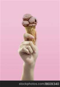 Ice cream cone on pink background, woman holding ice cream by hand