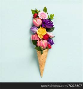 Ice cream cone with flowers and leaves. Summer minimal concept. Flat lay.