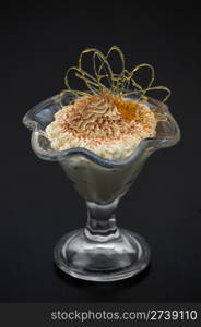 ice cream in glass bowl dusted with chocolate and decorated with caramel curl