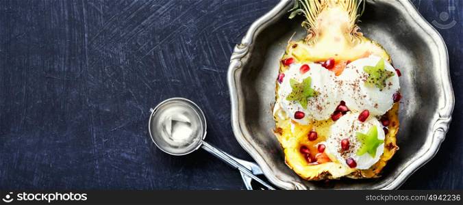 Ice cream pineapple vanilla. Ice cream in pineapple bowl, decorated with kiwi and pomegranate.Icecream dessert