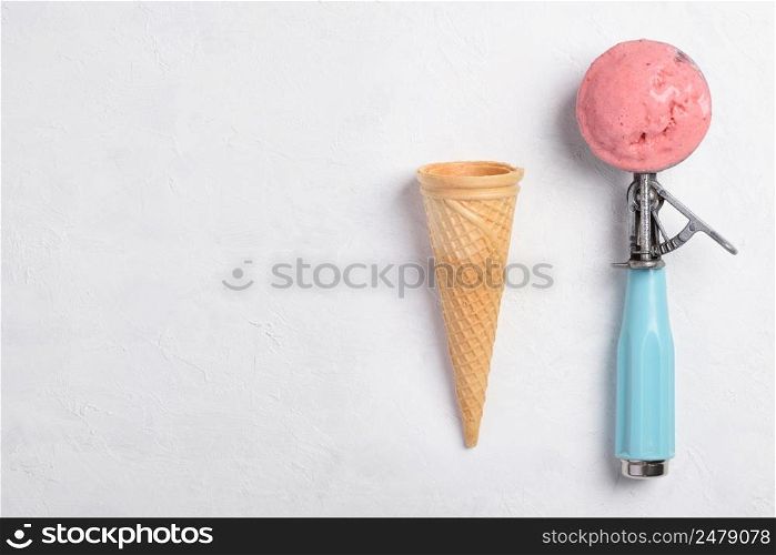 Ice cream spoon with homemade icecram scoop with wafer cone on white table background topview flatlay with copy space