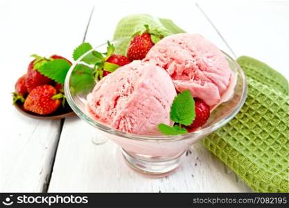 Ice cream strawberry in a glass with berries and mint, napkin on a light wooden board background