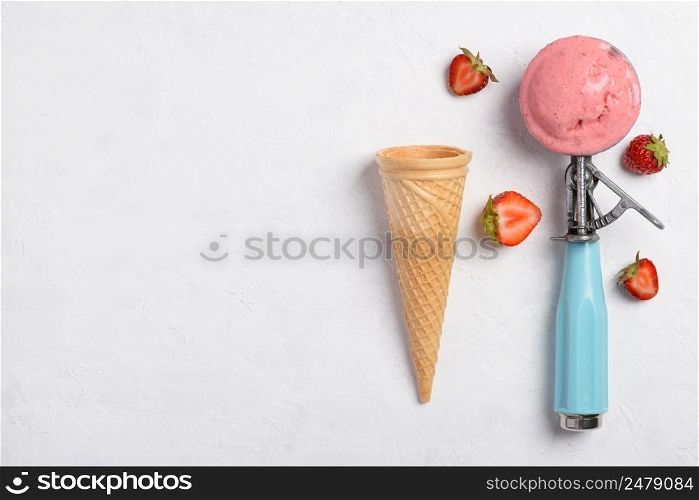Ice cream strawberry taste scoop in spoon with waffle cone on white table background flatlay top view with copy space