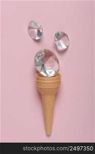 Ice cream waffer cone with shiny gems on pink pastel background flatlay
