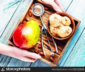 Ice cream with mango flavor. Ice cream, mango fruit and a spoon for ice cream in wooden tray