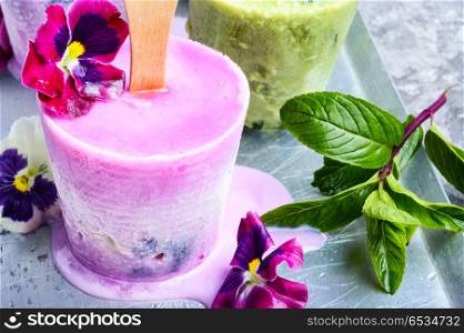 Ice cream with taste of flowers. Summer vanilla ice cream with fresh flowers and mint