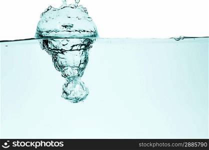 Ice cube splash into clear liquid