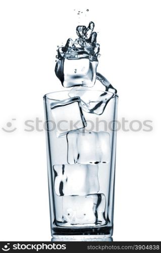 ice cubes dropped into glass with bubbles isolated on white