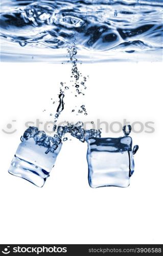 ice cubes dropped into water with bubbles isolated on white