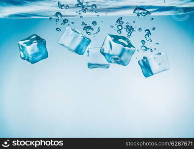 Ice cubes falling into the water sinking to the bottom. Abstract background.