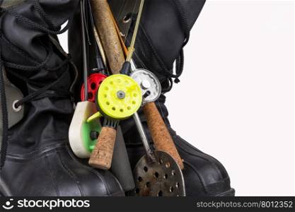 ice fishing tackles and winter boots on white background