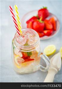 Ice fizzy Strawberry lemonade with mint and lemon in Mason jar