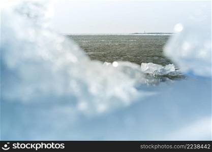 Ice floe breaking up against shore with sea ice during freezing winter weather. Shelf ice. Ice floe blocks from drift ice driven ashore during severe winter weather